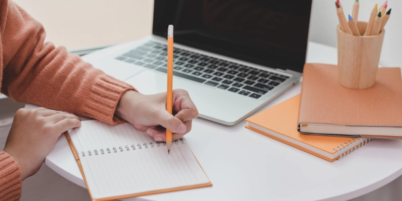 Personne prenant des notes depuis son ordinateur portable