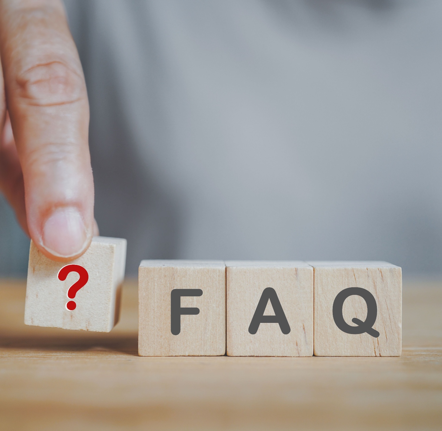 Wooden squares illustrating the word FAQ and a question mark