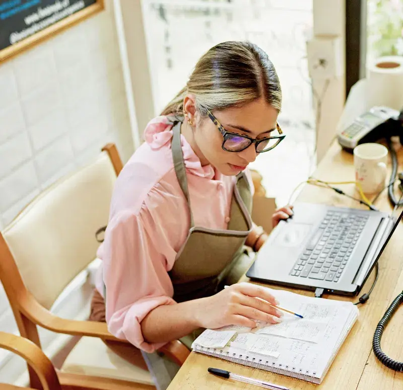 Small business owner calculating her taxes in her store